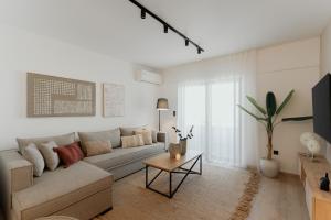 a living room with a couch and a table at The Edge Piraeus Luxury Residences in Piraeus
