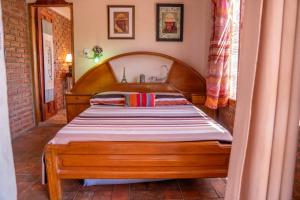 a bedroom with a wooden bed in a room at Cabaña Renacer in Samaipata