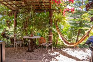 a patio with a table and chairs and a hammock at Cabaña Renacer in Samaipata