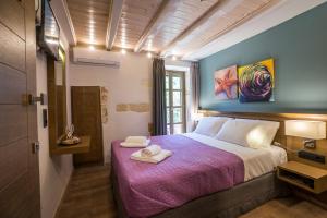a bedroom with a bed with a purple blanket at 11City Rooms in Chania Town