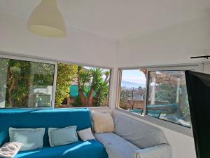 a blue couch in a room with large windows at Chez Anne in La Ciotat