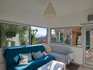 a living room with a blue couch and windows at Chez Anne in La Ciotat