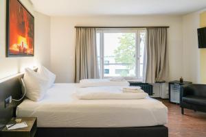 a hotel room with two beds and a window at feRUS Hotel in Lucerne