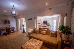 a living room with a couch and a table at The Paper Fig House in Plettenberg Bay