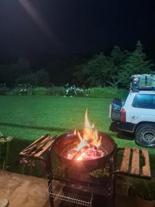 a bbq on a grill in a yard at night at Sheeprun Farmstay in Maclear