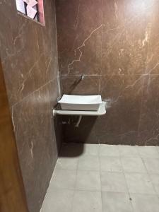 a bathroom with a toilet and a sink on a wall at hotel belva in Ahmedabad +3 photos