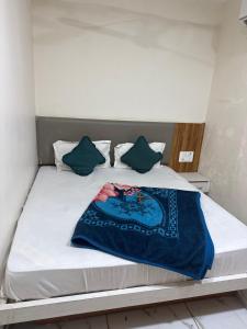 a bed with a blue blanket on top of it at hotel belva in Ahmedabad
