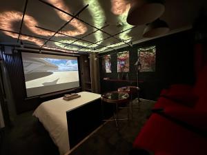 a room with a bed and a large screen television at Jacuzzi et Cinéma, Merignac2 in Mérignac