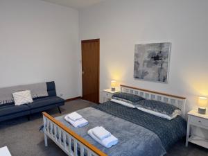 a bedroom with a bed and a couch at Ben Lomond Apartment - Macaulay Letting in Alexandria