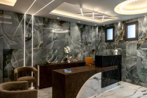 a lobby with a reception desk and chairs at Kudos Suites Firostefani in Fira +136 photos