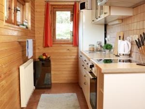 a small kitchen with wooden walls and counters and a window at Chata Sova Tále in Bystrá +26 photos