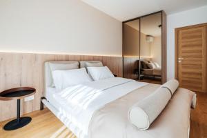 a bedroom with a large white bed and a mirror at APART 28 - Premium Suites in Podgorica