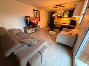 a living room with a couch and a dining room at Atelier chaleureux 40m2 - proche CDG Parc des expo in Tremblay-En-France