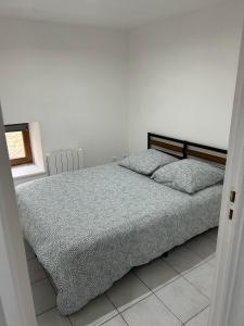a bedroom with a bed with two pillows on it at Maison proche lac de Madine in Buxières-sous-les-Côtes
