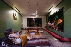 a woman sitting on a couch in a living room at ANOU HOSTEL in Pakse