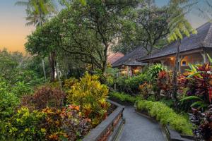 a garden in front of a house with flowers at Taman Indrakila in Ubud