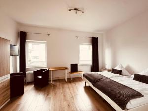 a bedroom with a bed and a desk in it at Oberkasseler Hof Bonn in Bonn