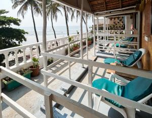 a porch with chairs and the beach in the background at This is it Stays - Beach View Rooms & Huts in Arambol