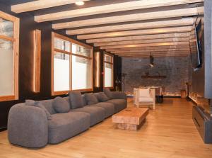 ein Wohnzimmer mit einem großen Sofa und einem Tisch in der Unterkunft Hotel Victor in Rialp