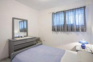 a bedroom with a bed and a dresser and a mirror at Onar holiday home in Fourka