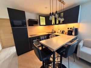 a kitchen with a table and chairs in a room at Atelier chaleureux 40m2 - proche CDG Parc des expo in Tremblay-En-France