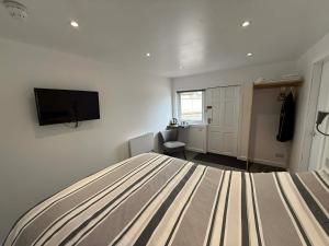 a bedroom with a bed and a flat screen tv at The Carisbrooke in Forres