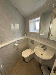 a bathroom with a white toilet and a sink at The Carisbrooke in Forres