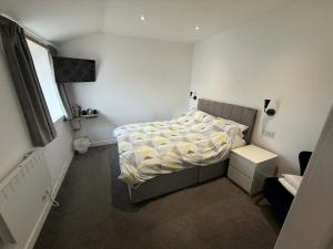 a small bedroom with a bed and a window at The Carisbrooke in Forres