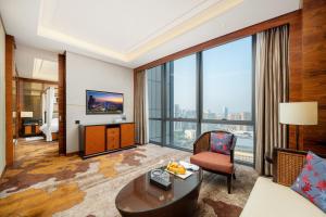 a living room with a large window at Dongguan Kande International Hotel in Dongguan