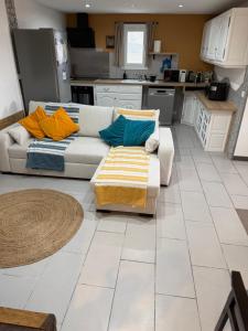 a living room with a couch and a kitchen at Appartement deux chambres spacieux avec jardin et entièrement privatif dans lotissement très calme in Biguglia