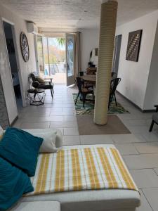 a living room with a bed and a dining room at Appartement deux chambres spacieux avec jardin et entièrement privatif dans lotissement très calme in Biguglia