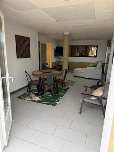 a living room with a table and chairs at Appartement deux chambres spacieux avec jardin et entièrement privatif dans lotissement très calme in Biguglia