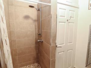 a shower with a glass door in a bathroom at River Cottage in Penrith +27 photos