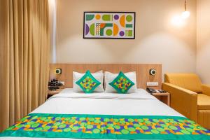 a bedroom with a bed and a chair at Treebo Alfa Suites in Mumbai +42 photos