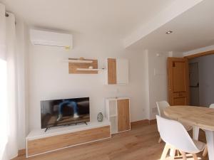 a living room with a table and a television at La Ostra De Benidorm in Benidorm
