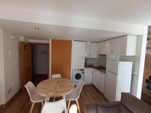 a small kitchen with a wooden table and white appliances at La Ostra De Benidorm in Benidorm