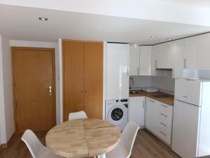 a kitchen with a wooden table and white appliances at La Ostra De Benidorm in Benidorm