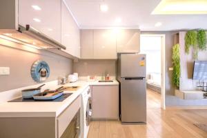 a kitchen with a refrigerator and a stove at Dazzle Residence Sukhumvit Bangkok in Bangkok +72 photos