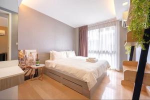 a bedroom with a bed and a large window at Dazzle Residence Sukhumvit Bangkok in Bangkok