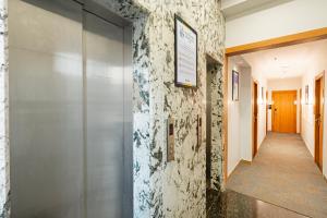 a hallway in a building with a sign on the wall at Treebo Alfa Suites in Mumbai