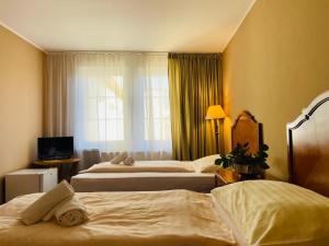 a hotel room with three beds and a window at DAEGA with daehan in Žilina