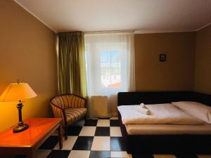 a bedroom with a bed and a chair and a window at DAEGA with daehan in Žilina