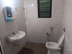 a bathroom with a toilet and a sink at Serene Green Park in Canacona