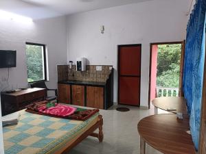 a living room with a bed and a table at Serene Green Park in Canacona