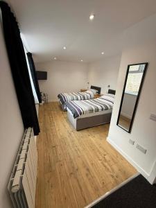 a bedroom with two beds and a mirror on the wall at The Carisbrooke in Forres