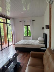 a bedroom with a bed and a couch at Ratu Roso Resort in Malang