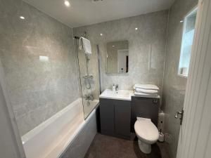 a bathroom with a toilet and a sink and a shower at The Carisbrooke in Forres +11 photos
