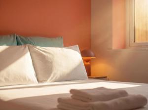 a bedroom with a bed with white sheets and a window at Zozy Clitterhouse in London
