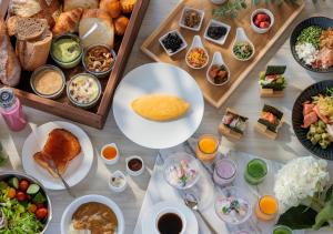 a table topped with plates of food and bowls of food at ANA Crowne Plaza Okayama by IHG in Okayama