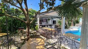 a patio with tables and chairs next to a pool at Silver Coast Pool & Resort Villas in Arnal +39 photos